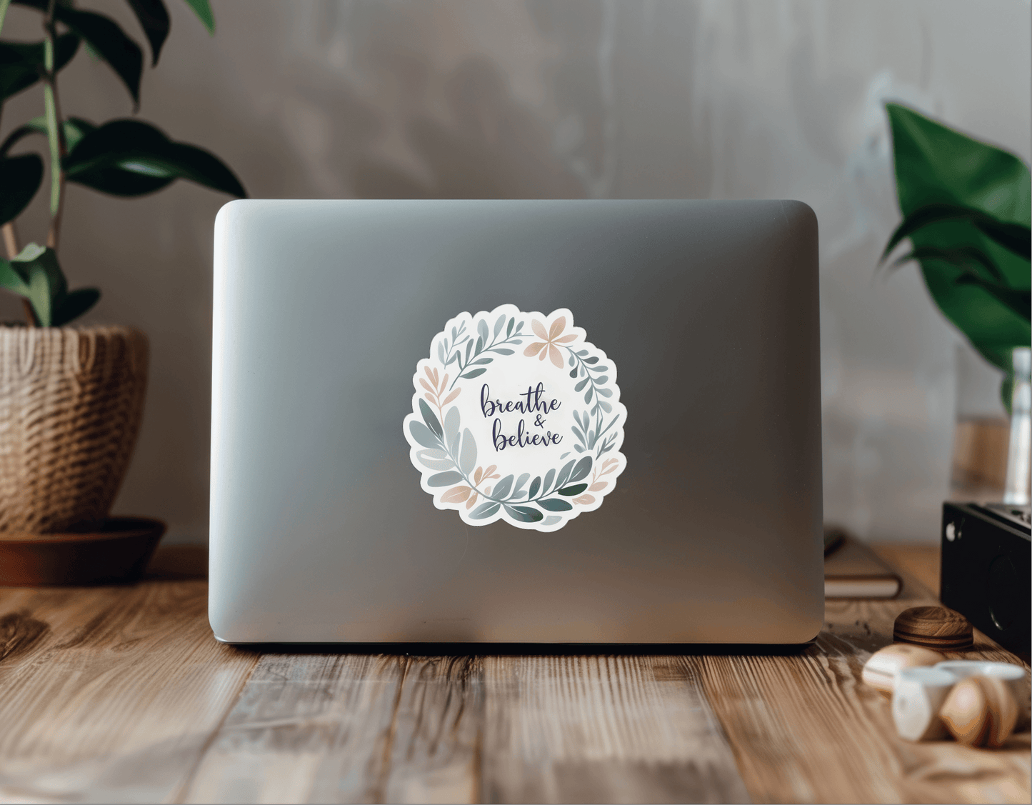 Breathe & Believe - Calming Message Sticker on a laptop surrounded by indoor plants and decor.
