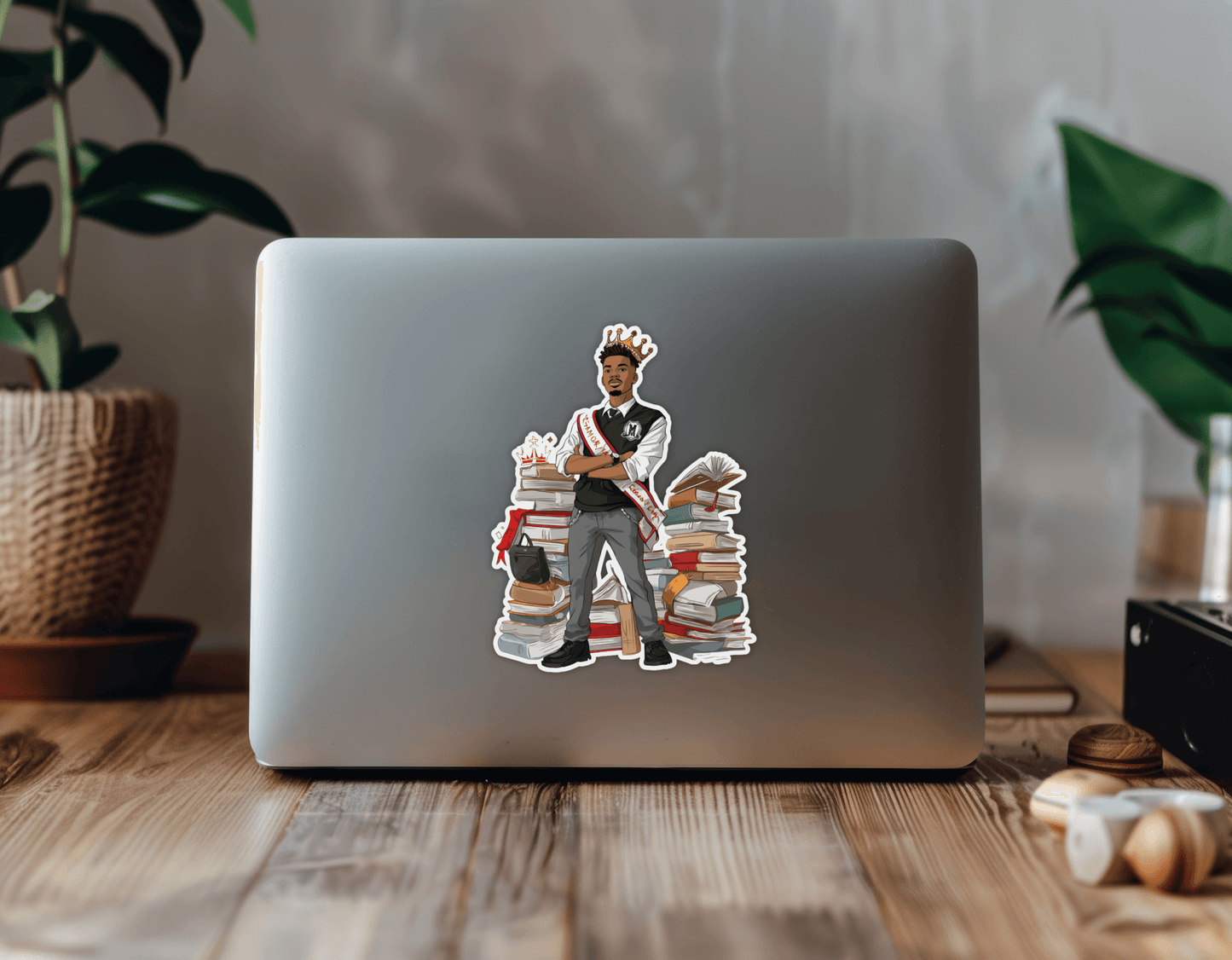 HBCU Campus Royalty Sticker on a laptop, showcasing a student with books and a crown, adding artistic flair.