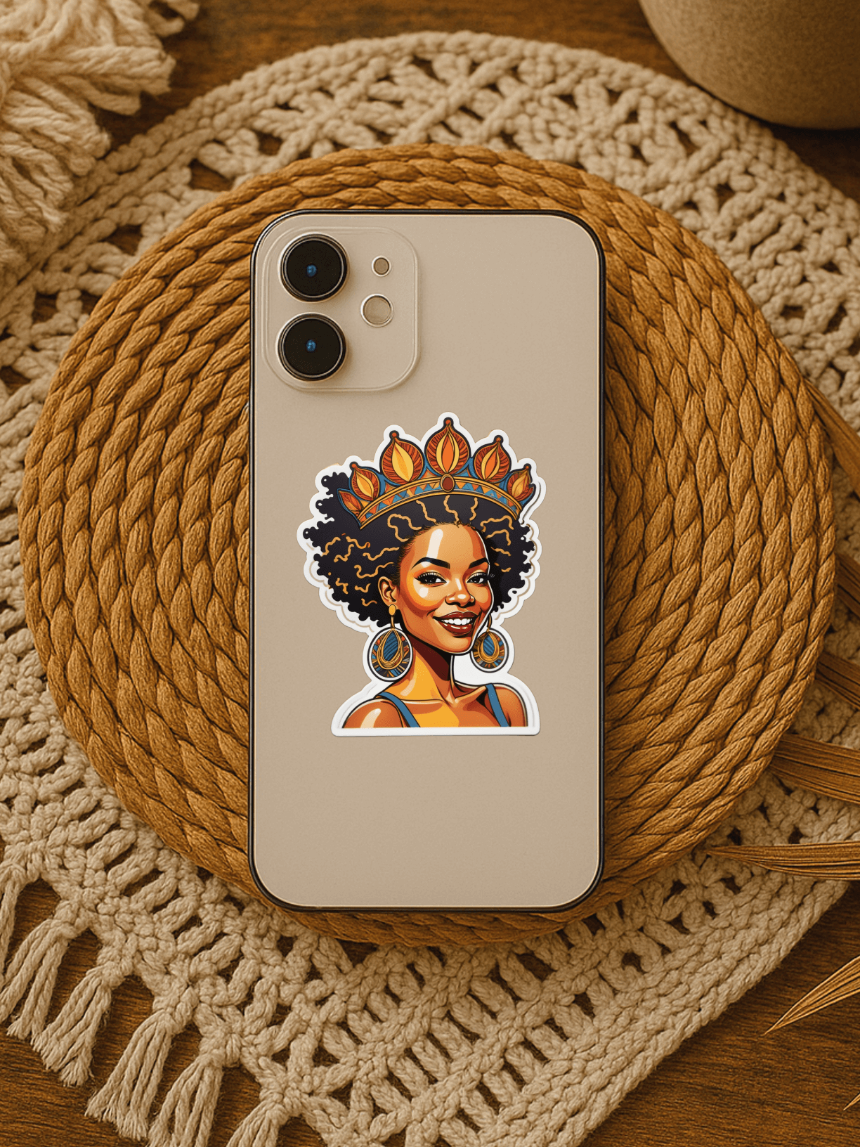 Radiant Afro Queen vinyl sticker on a phone over a woven placemat, showcasing HBCU pride and vibrant design.