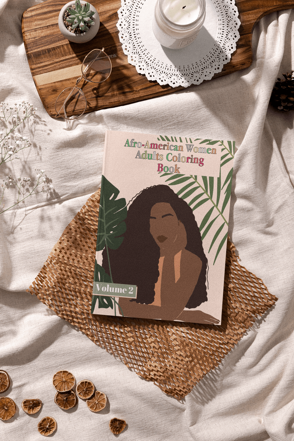 Afro-American Women Adults Coloring Book Volume 2 on a linen background with decorative elements.