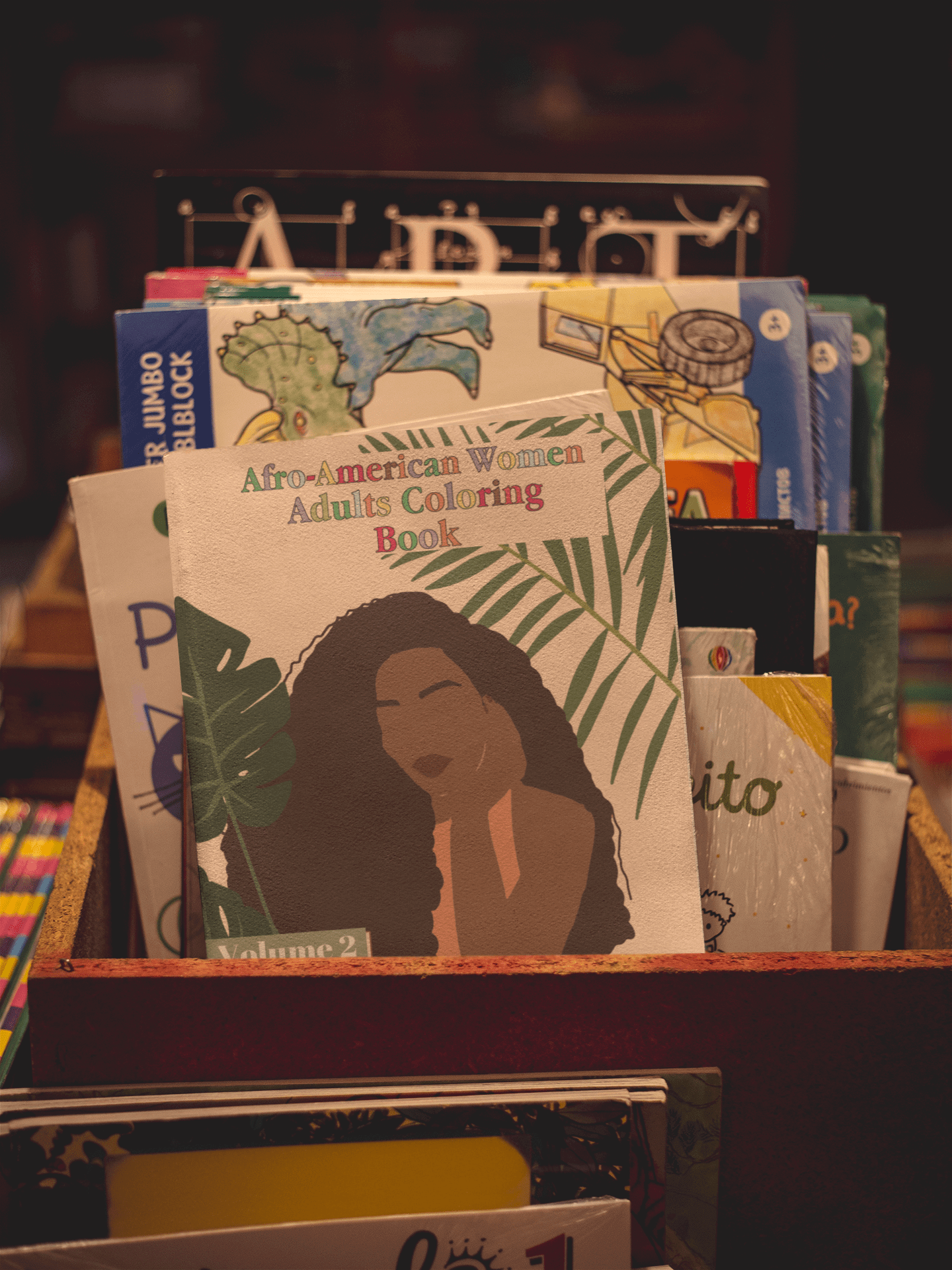 Afro-American Women Adults Coloring Book Volume 2 displayed among other books in a wooden box.