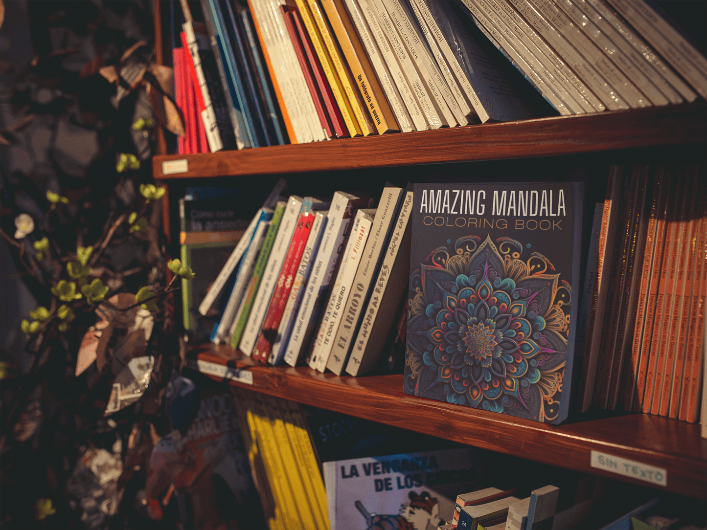 Amazing Mandala Coloring Book displayed on a wooden bookshelf among various other books.