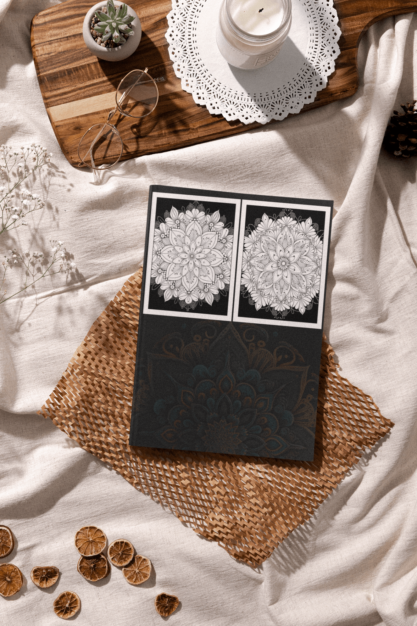 Amazing Mandala Coloring Book displayed on a woven mat, showcasing intricate black and white mandala designs surrounded by decorative items.