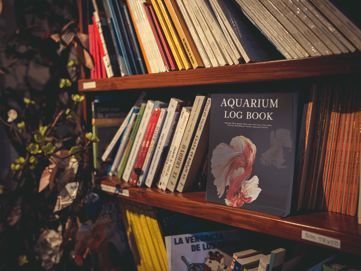 Aquarium Log Book displayed on a wooden shelf among other books, ideal for tracking aquarium maintenance.