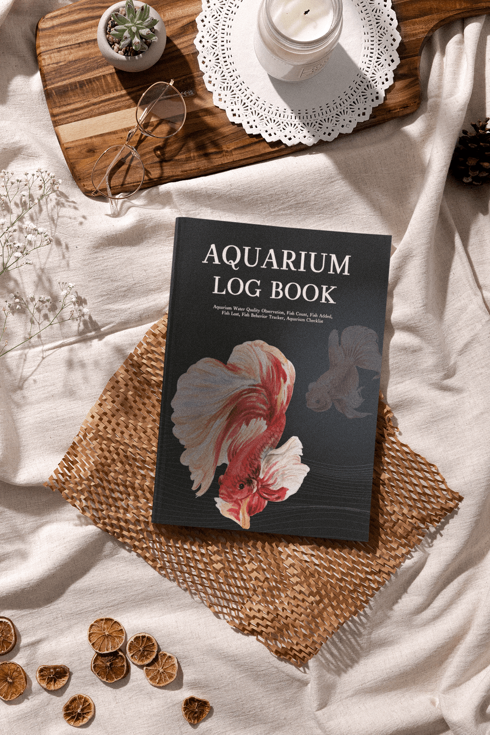Aquarium Log Book displayed on a textured mat with decorative items, perfect for tracking aquarium maintenance.