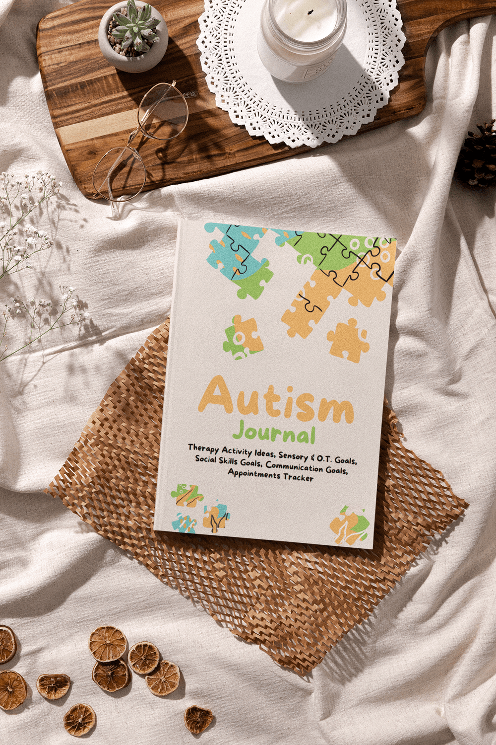 Autism Journal on a textured mat with puzzle design, candles, and decorative items for organizing special needs.