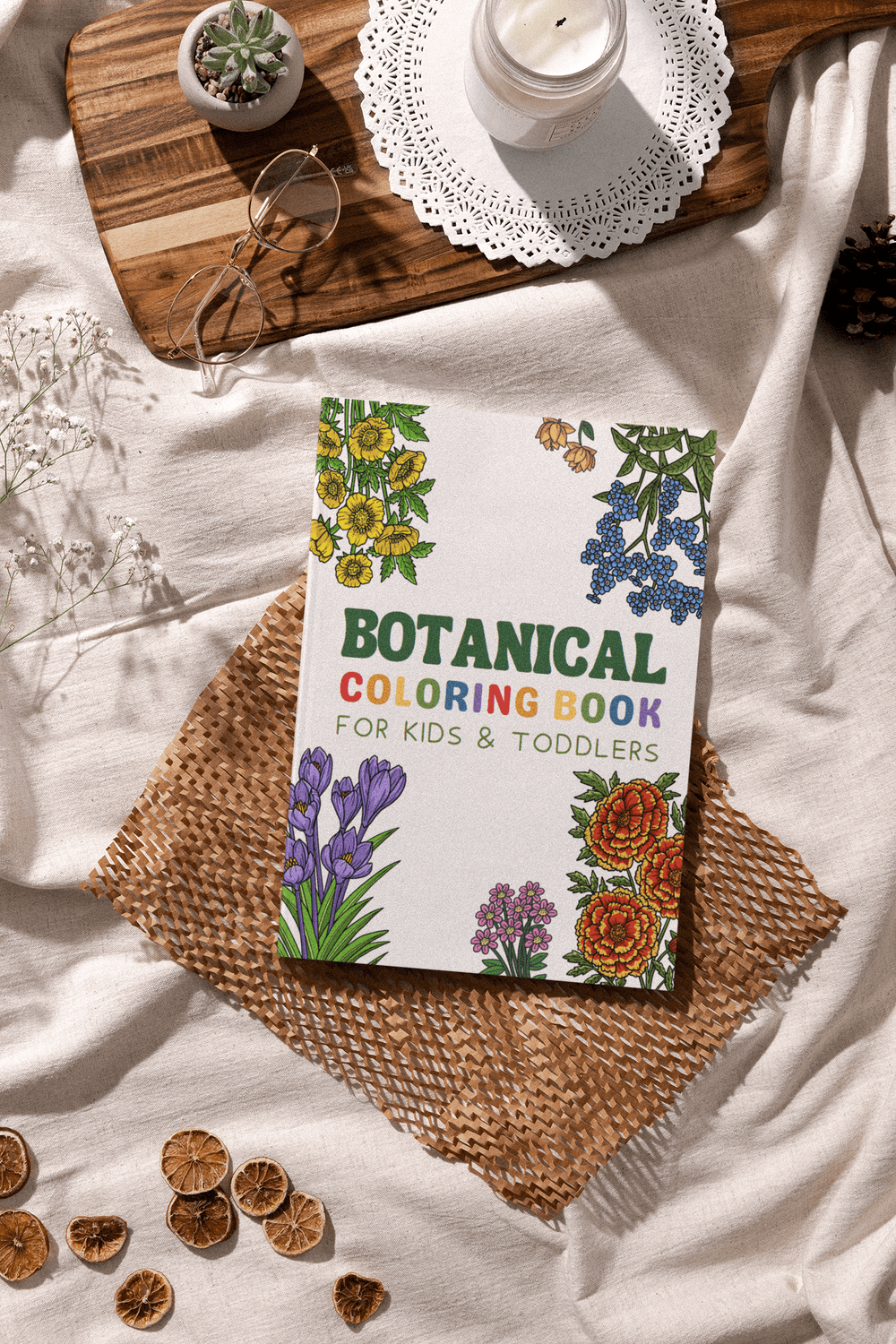 Botanical Coloring Book for Kids & Toddlers on a cozy table with flowers and decorative elements.