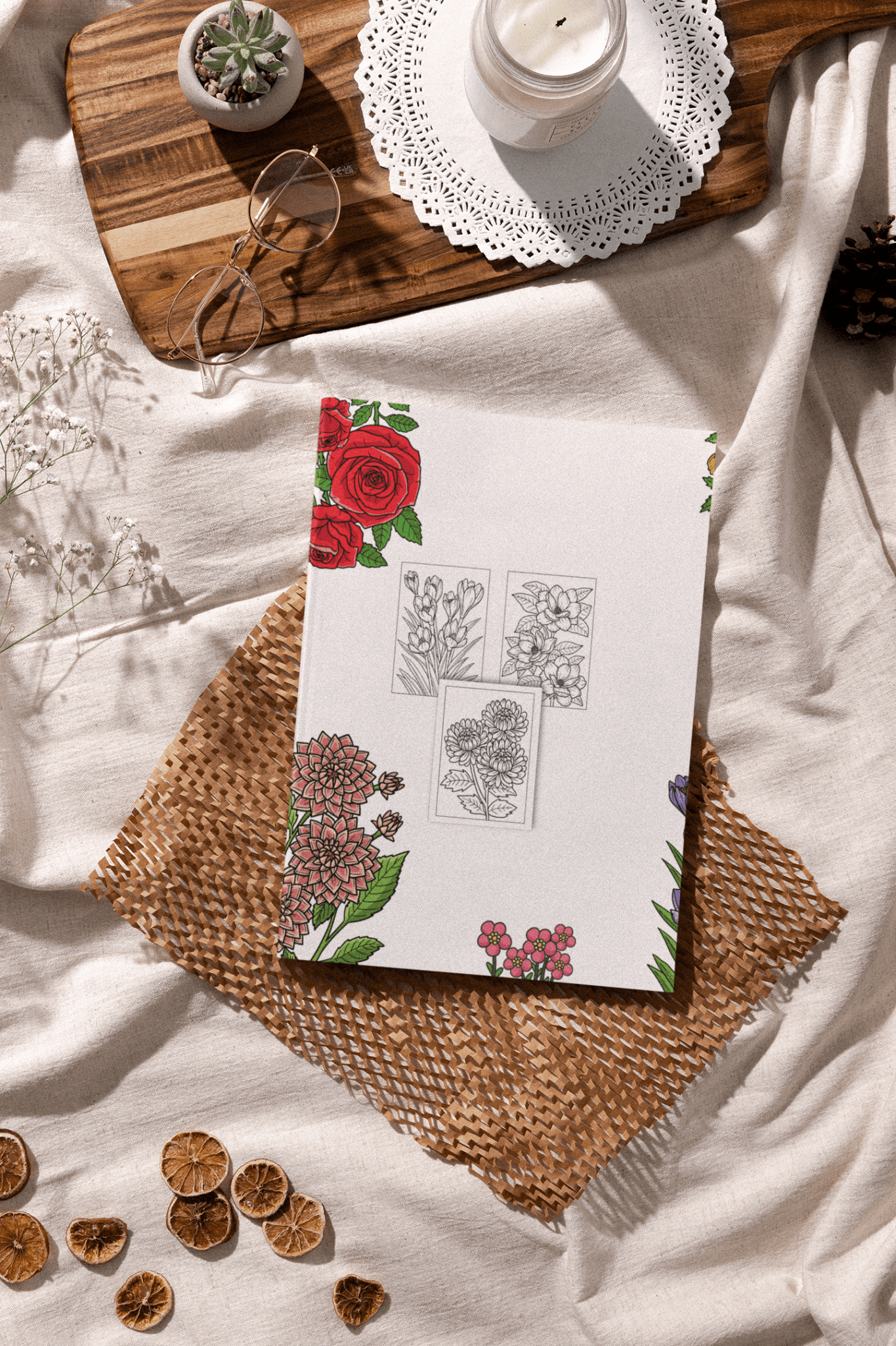 Botanical Coloring Book for Kids on a textured surface surrounded by nature-themed decor and a candle.