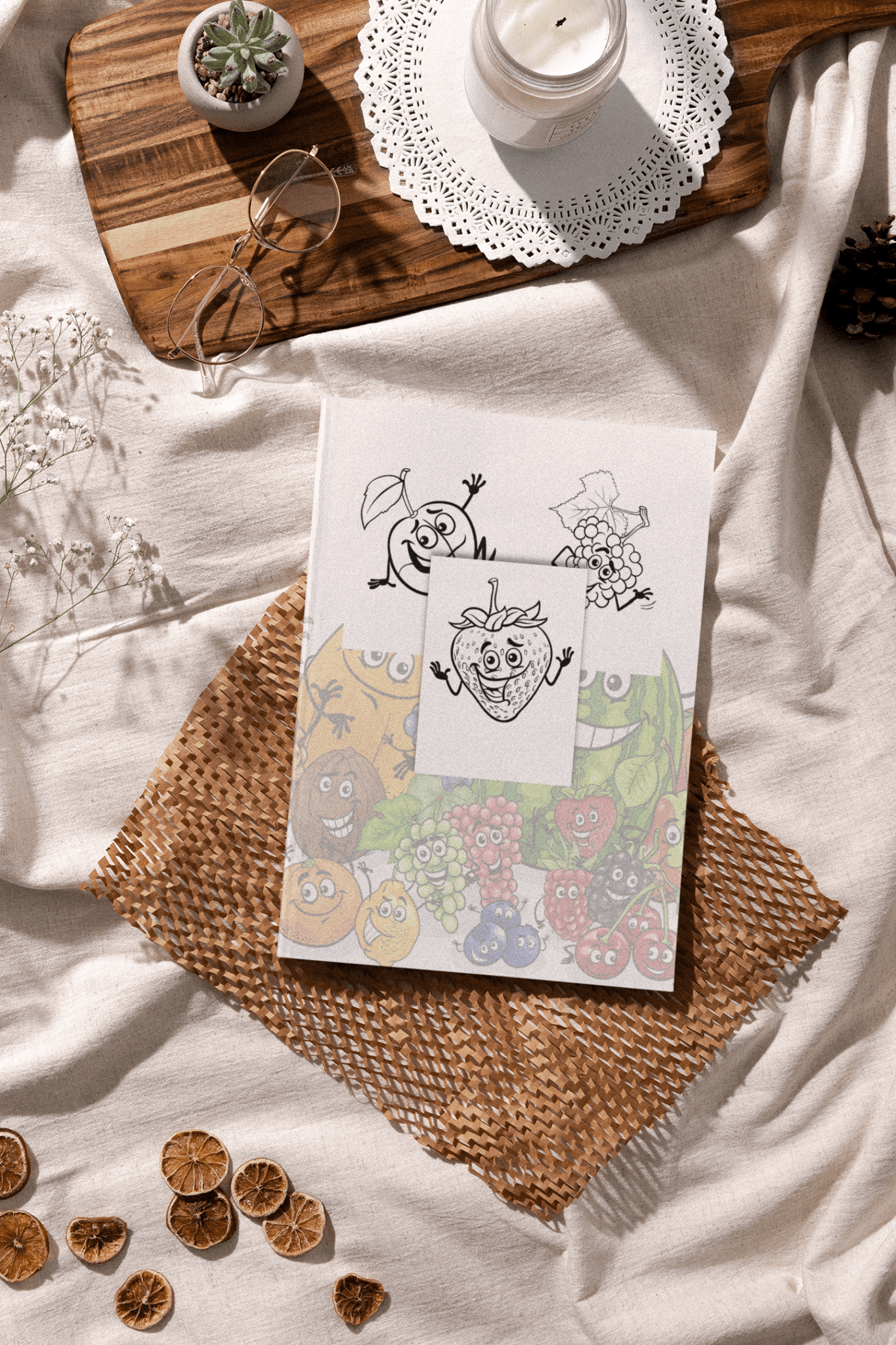 Cute Fruits & Vegetables coloring book displayed on a cozy table with glasses and a candle.