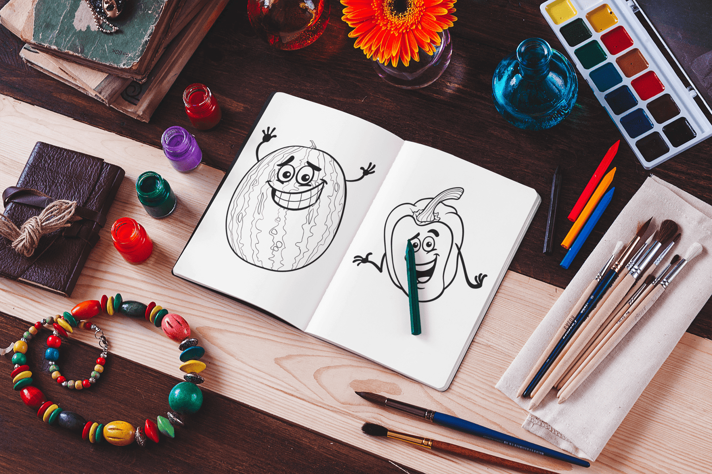 Open coloring book with fun fruit and vegetable designs, surrounded by art supplies and vibrant decorations.