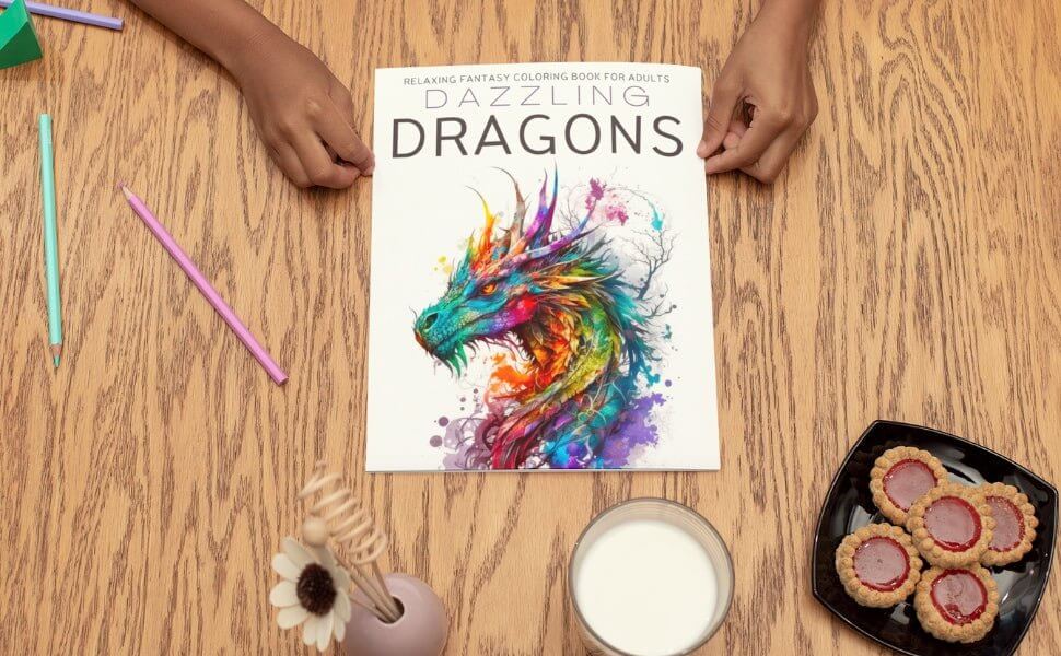Dazzling Dragons fantasy coloring book for adults on table with snacks and colorful pencils.