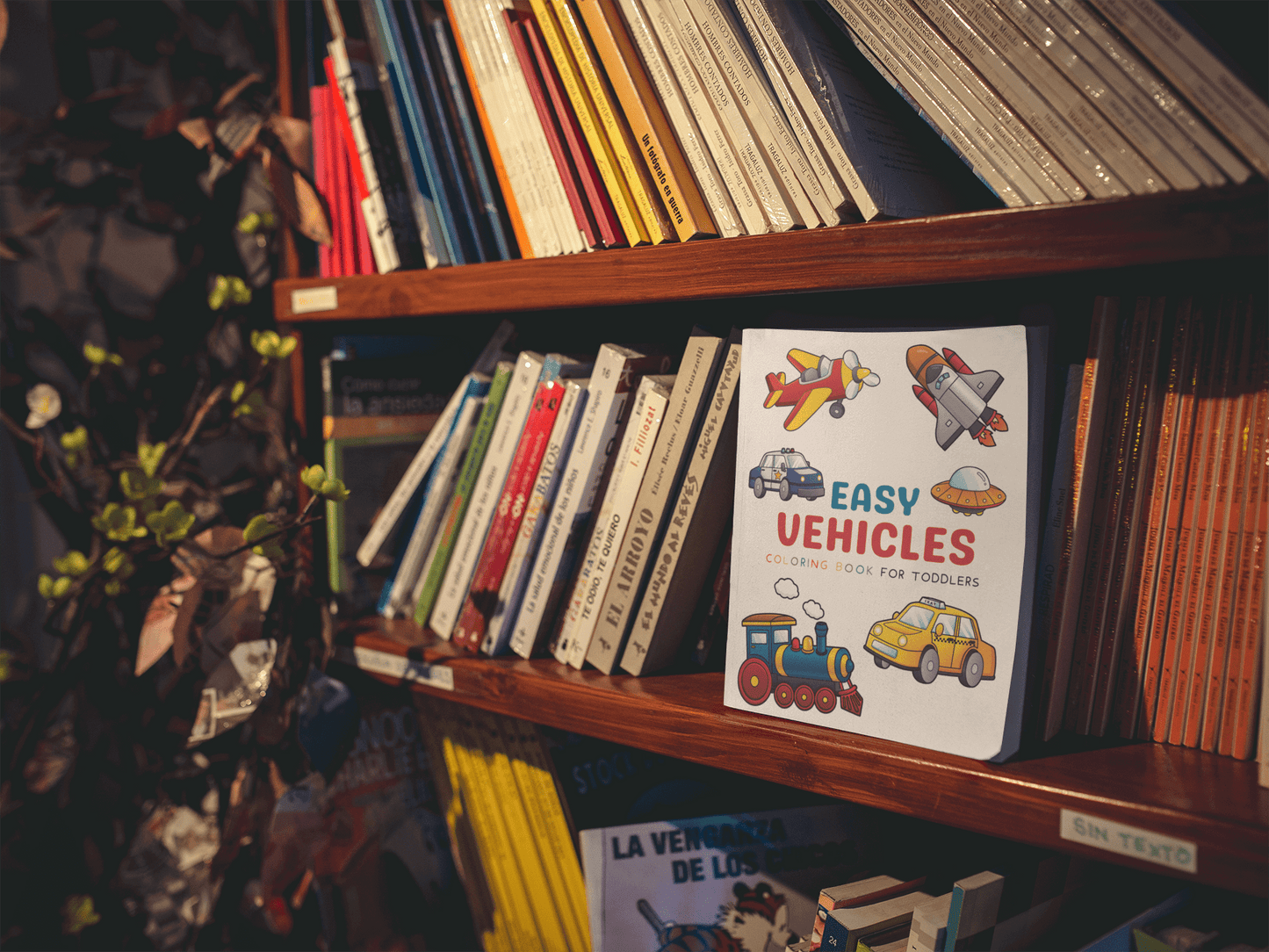 Easy Vehicles Coloring Book for Kids displayed on a shelf among other children's books, featuring colorful illustrations.