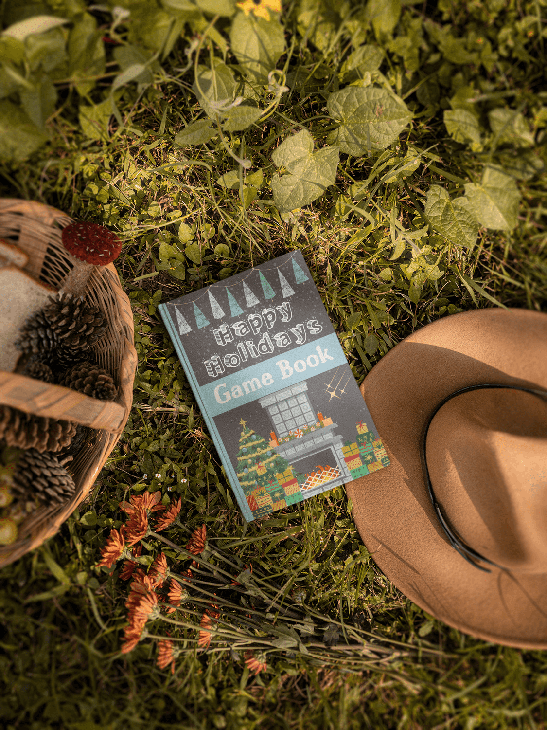 Happy Holidays Game Book on grass with flowers and a hat, perfect for holiday fun and family gatherings.
