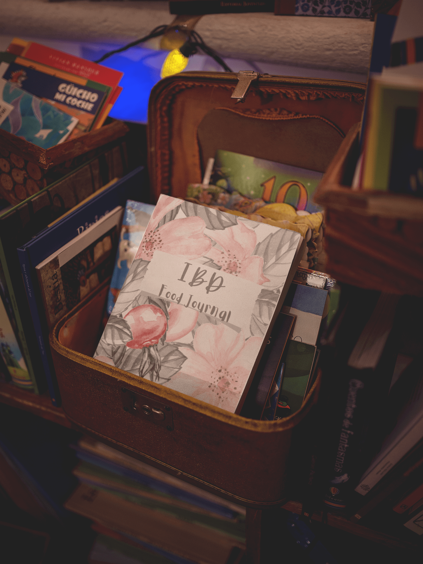 IBD Food Tracking Journal resting in a basket among books, designed for monitoring digestive health and food sensitivities.