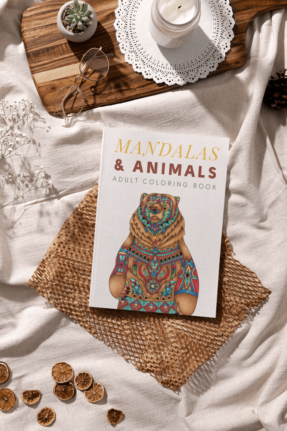 Mandalas and Animals Adult Coloring Book on a soft surface with decorative elements, promoting relaxation and creativity.
