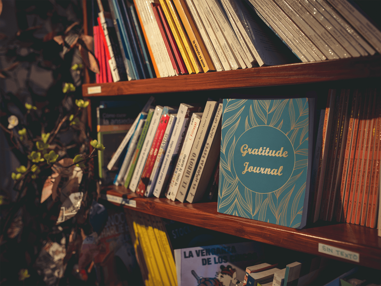 Multi-Colored Floral Gratitude Journal on a shelf among various books, showcasing its elegant design.