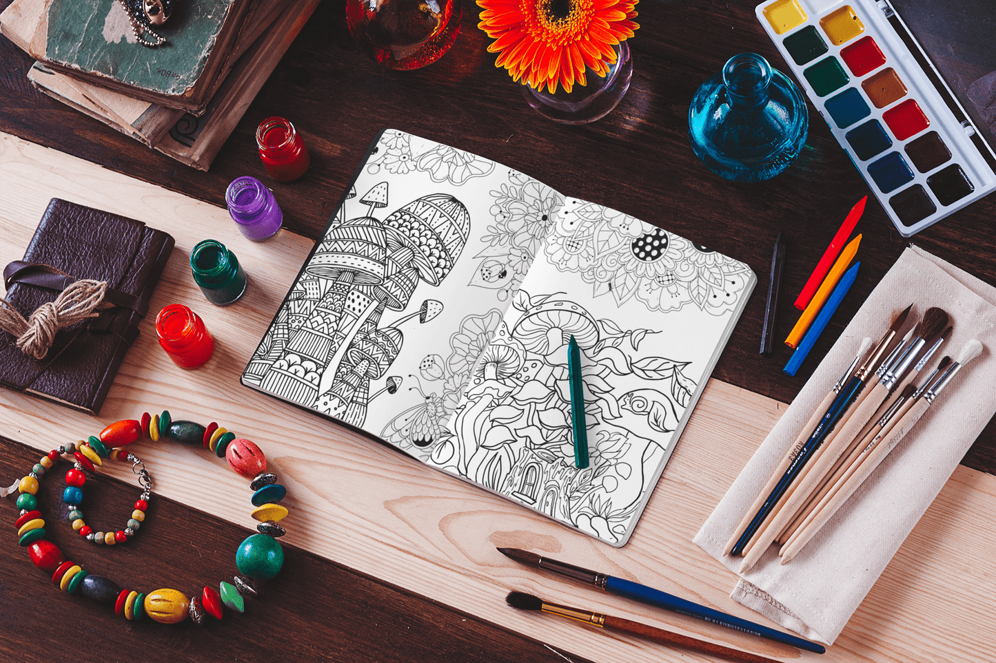 Coloring book open to psychedelic mushroom illustrations, surrounded by art supplies and vibrant flowers.