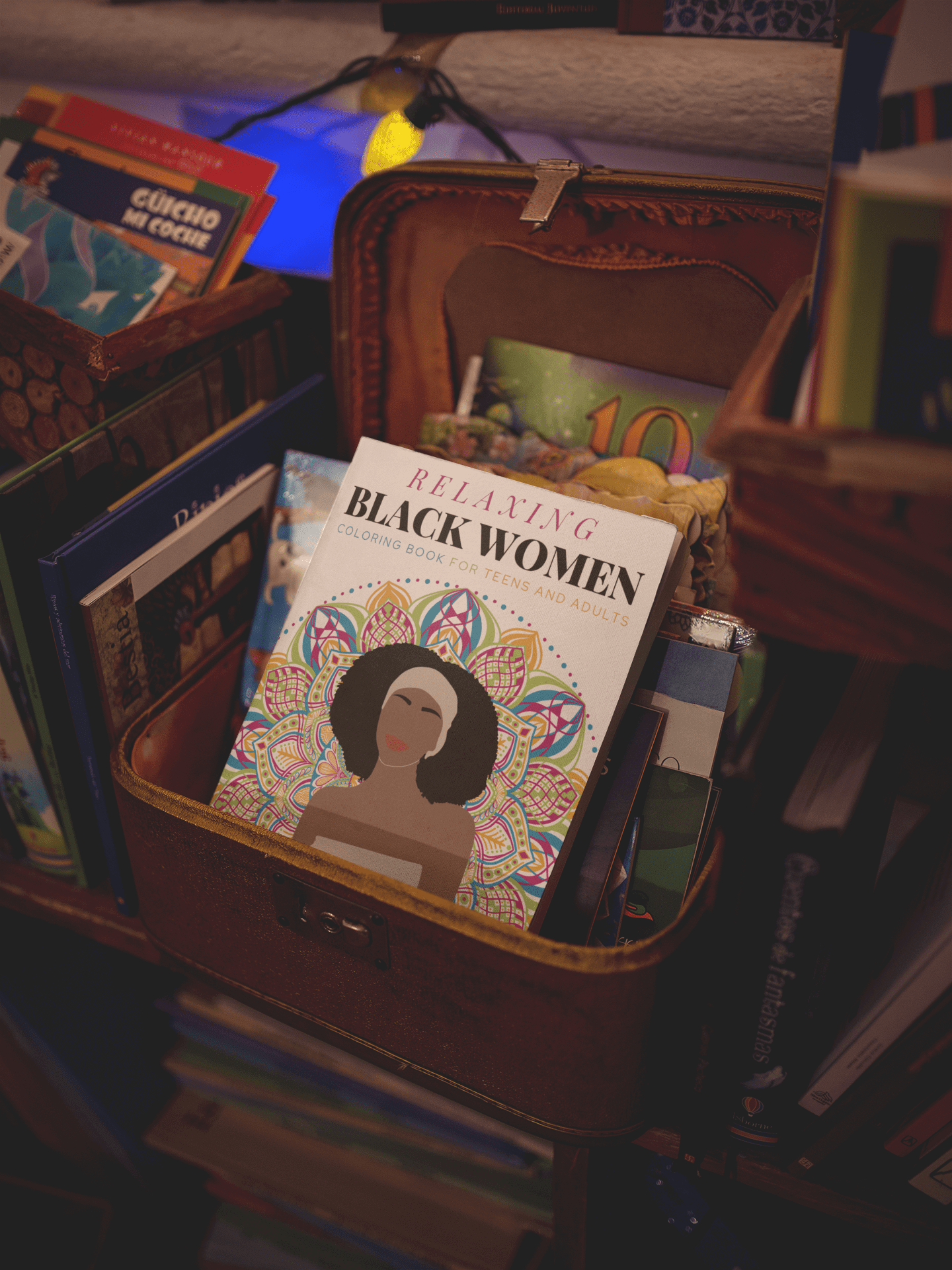 Cover of the 'Relaxing Black Women Coloring Book' displayed among other books in a cozy setting.