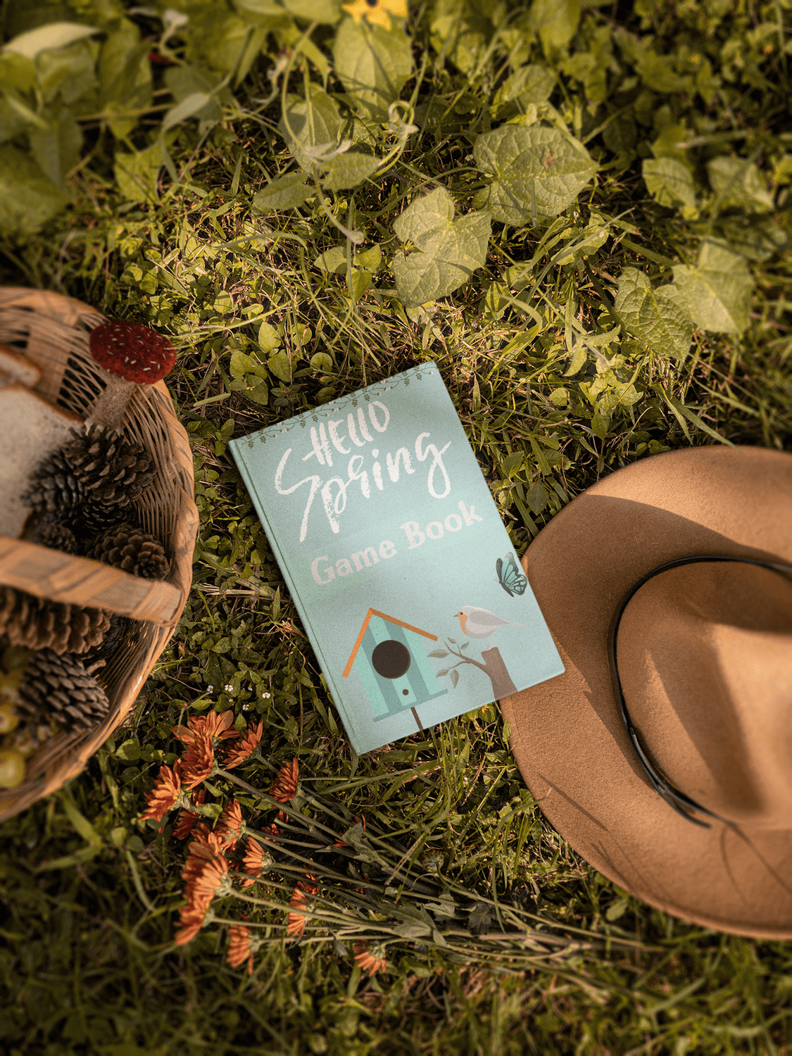 Spring-themed activity book on grass with hat and basket, perfect for stress-relief puzzles for all ages.