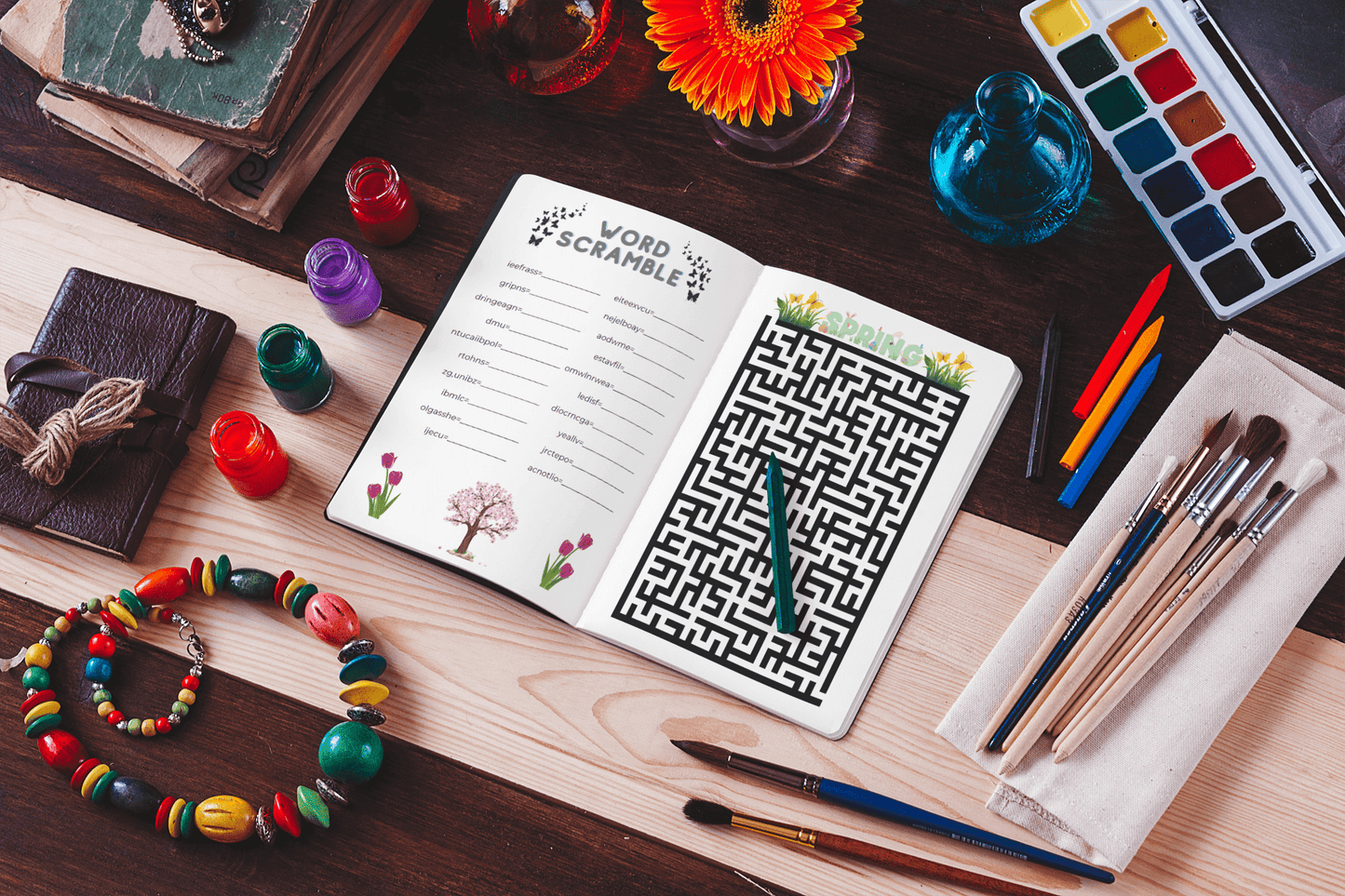 Spring Time Mix Activity Book open to word scramble and maze pages, surrounded by art supplies and vibrant decor.