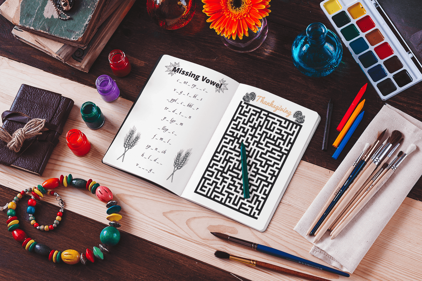 Open Thanksgiving Game Book featuring puzzles like 'Missing Vowels' and maze, surrounded by art supplies and colorful decorations.