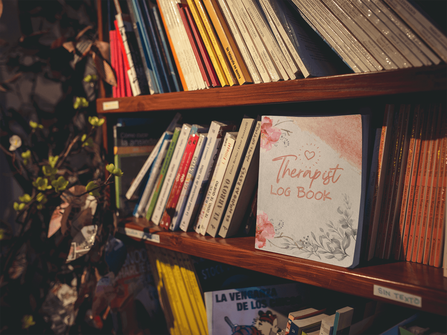 Therapist Log Book displayed on a wooden shelf among various books, ideal for organizing therapy sessions.