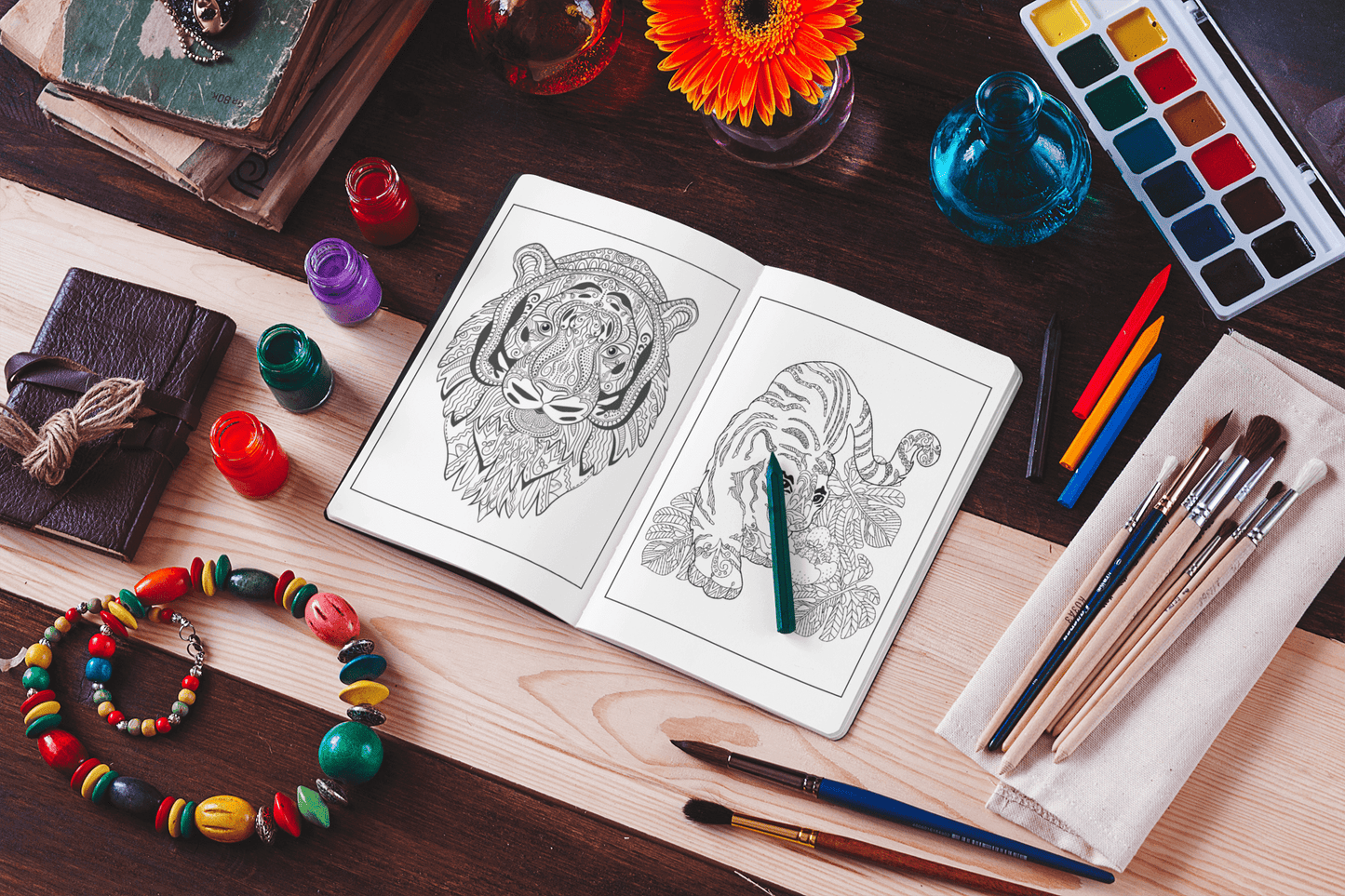 Open tiger coloring book with colorful pencils and art supplies on a wooden table, perfect for stress relief.