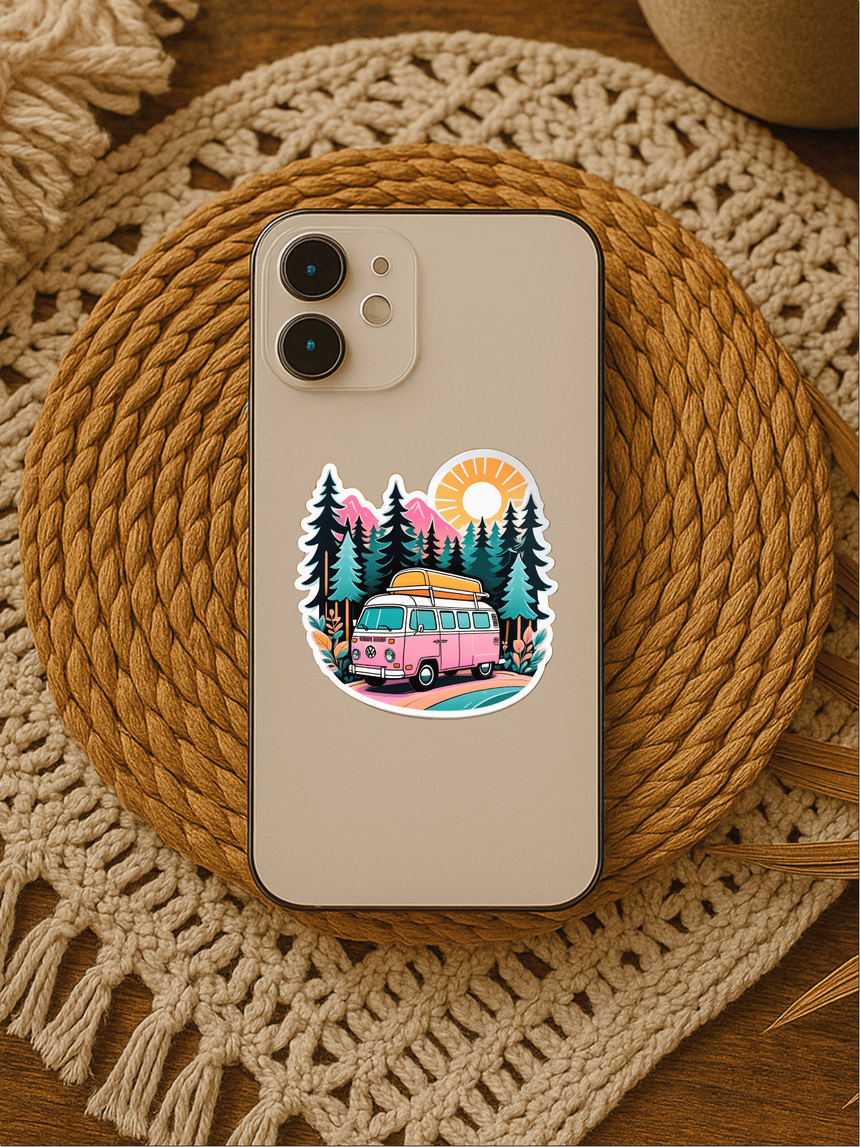 Chill Vanlife Sticker on a phone featuring a colorful van and trees design, sitting on a woven mat.