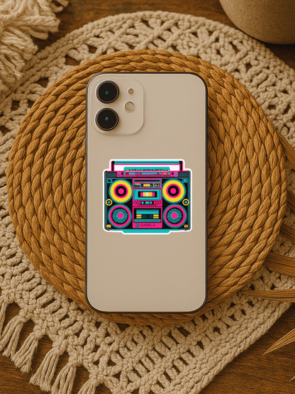 Colorful retro boombox vinyl sticker on a smartphone atop a woven mat.