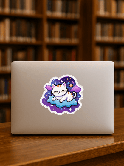 Cosmic Catnap – Galaxy Space Cat Vinyl Sticker on a laptop cover in a library setting.