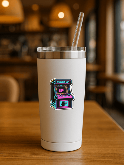 Retro Arcade Power vinyl sticker on a white tumbler with a straw in a cozy cafe setting.